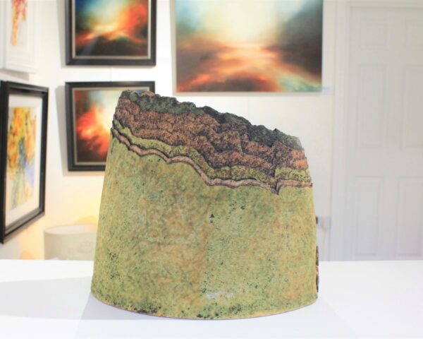 Landscape Vessel 9 by Cumbrian sculptural artist Nigel Edmondson. Hand-built using techniques in slab construction, coiling, throwing and often both in combination. Each piece is fired to a temperature of 1250C in oxidation, ensuring his creations can endure all weathers for the years to come. Landscape Vessel 9 is a 9” vessel made using clay. The layers of the clay are reminiscent of the fells of the Lake District, each with a different earth tone in colour.