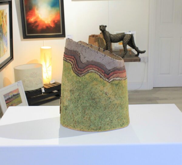 Landscape Vessel 6 by Cumbrian sculptural artist Nigel Edmondson. Hand-built using techniques in slab construction, coiling, throwing and often both in combination. Each piece is fired to a temperature of 1250C in oxidation, ensuring his creations can endure all weathers for the years to come. Landscape Vessel 6 is a 10.5” vessel made using clay. The layers of the clay is reminiscent of the fells of the Lake District, each with a different earth tone in colour.