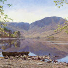classic lake district view of buttermere from dalegarth over the still water towards high crag and haystacks with shoreline and rowboat in the foreground by lake district artist keith melling