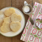 Organic Cotton Honesty Seed design tea towel by Miller Honeyman shown folded with heart shaped biscuits.