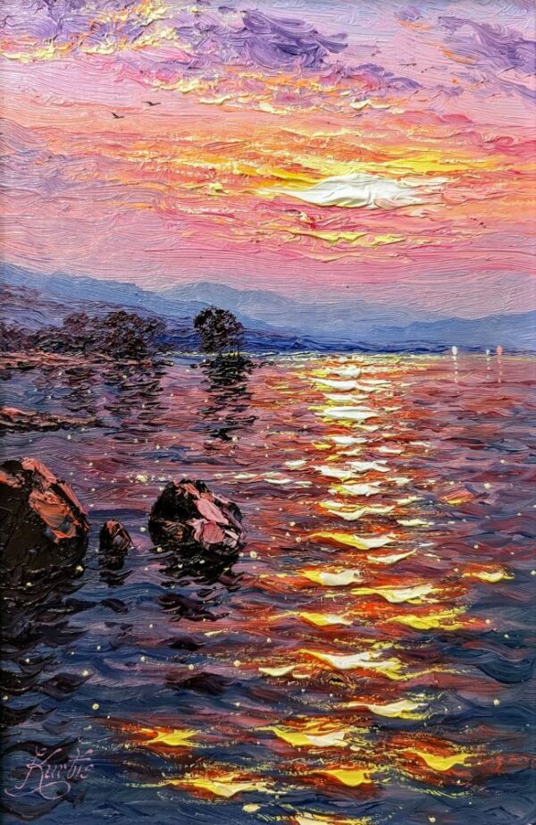 Lake district art by Andrew Grant-Kurtis. Sunshine Breeze Derwentwater features a reflective pink and purple sunset over the lake with distant mountains boats and trees.