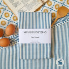 Ribbon Stripe Blue organic cotton tea towel by local textile designer Miller Honeyman featuring a rabbit in the bottom right corner