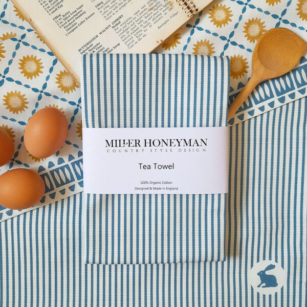 Ribbon Stripe Blue organic cotton tea towel by local textile designer Miller Honeyman featuring a rabbit in the bottom right corner