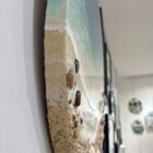 Lake District art gallery. Our Sunlit Bay by Tamsin Pease. A resin mixed media piece with mica powders and acrylic inks. Real sand and pebbles used to create an aerial shoreline