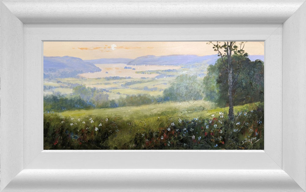 Lake District art original oil painting by Jeff Sudders. Summer at Waterhead featuring green meadows overlooking lake Windermere at sunset. Displayed in a white cushioned frame.