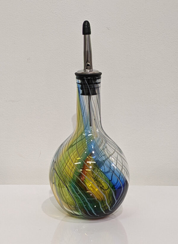 Handmade glass oil pourer. Rounded bottle bottom. Kingfisher feather colours, yellow, blue, red and greens.