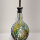 Oil pourer in kingfisher feather colours. Yellow, blue, red and greens. Rounded bottle bottom.