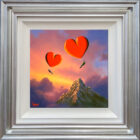Lake District original art by David Renshaw featuring ted and doris with heart balloons in front of a large mountain and sunset. In blue silver frame.