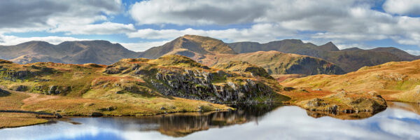 A view of Angletarn Pikes reflected in water on a clear summer's day.