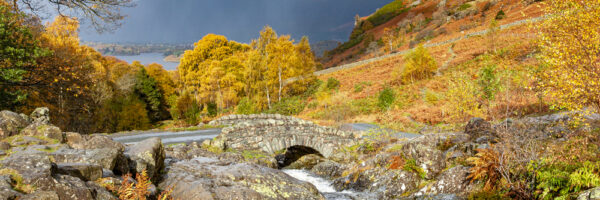 The traditional stone built Ashness Bridge in Keswick with a view across Borrowdale towards Skiddaw.