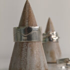 A chunky silver ring featuring a mountain range silhouette wrapping around its band and a hammered texture edge. Approximately 0.75” in diameter.