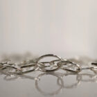 A handcrafted silver chain featuring a flowing arrangement of oval and raindrop shaped motifs. Chain is approximately 8“ in length.