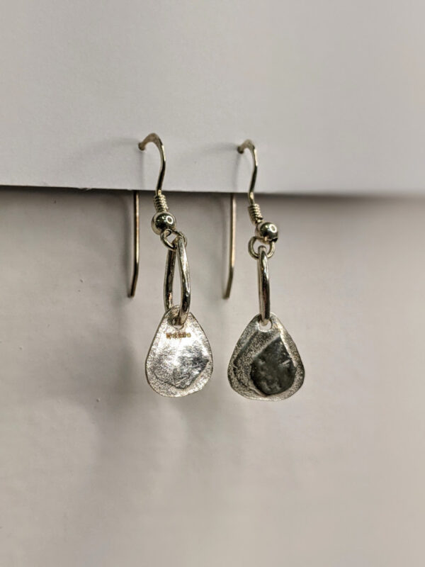 Handcrafted silver earrings featuring a printed raindrop pendant. Approximately 1.75” in length. Side view