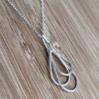 A handcrafted silver necklace showcasing four intertwined raindrop pendants. Chain is approximately 9“in length. Raindrop pendants approximately 1.75”.
