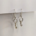 Handcrafted silver earrings featuring a delicate raindrop pendant. Approximately 1.75” in length. Side view.