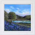 Lake District art original oil painting Rannerdale Bluebells by Ben Goymour. Bright blue skies fields of bluebells and a large tree with fell range in the distance. Displayed in a white frame.