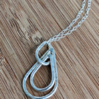 A handcrafted silver necklace showcasing three raindrop pendants with a hammered texture. Chain is approximately 9“in length. Raindrop pendants approximately 1.25”.
