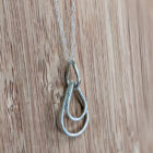 A handcrafted silver necklace showcasing three raindrop pendants with a hammered texture. Chain is approximately 9“in length. Raindrop pendants approximately 1.25”.