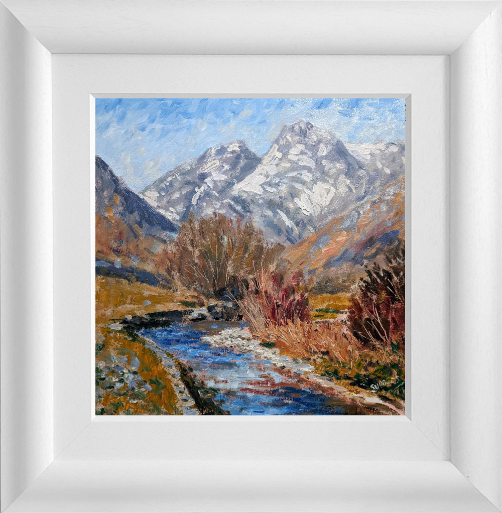 Lake District art original oil painting by Jeff Sudders featuring Snow on the Tops in the Langdale Valley. A flowing river trees in the foreground with snowy mountains in the distance. Displayed in a white wood grain frame.