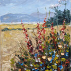 Oil painting of a wildflower-filled field under a pale blue sky. Red and blue flowers bloom in the foreground, with tall white flower clusters rising above them. Golden grasses stretch into the distance toward soft blue hills and a line of dark trees, painted with visible, textured brushstrokes.