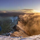 Print by Lake District Photographer Nathan Buckley. Sunrise over striding edge. panomaric view from helvellyn of misty fell red tarn ullswater in winter snow