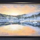 A limited edition print on canvas by Ben Goymour featuring lake Windermere during sunset. Water is still showing the reflection of hills and orange skies. Sailboats floating on the lake. Displayed in a balck frame with bronze trim.