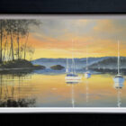 Lake District art original oil painting by Ben Goymour featuring Windermere. Boats floating on the water with a bright orange sunset. Displayed in a black frame.