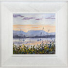 lake district art original oil painting by local artist Jeff Sudders featuring a soft evening sunset set across lake Windermere sailboats floating in the water and flowers in the foreground. Displayed in a white frame.