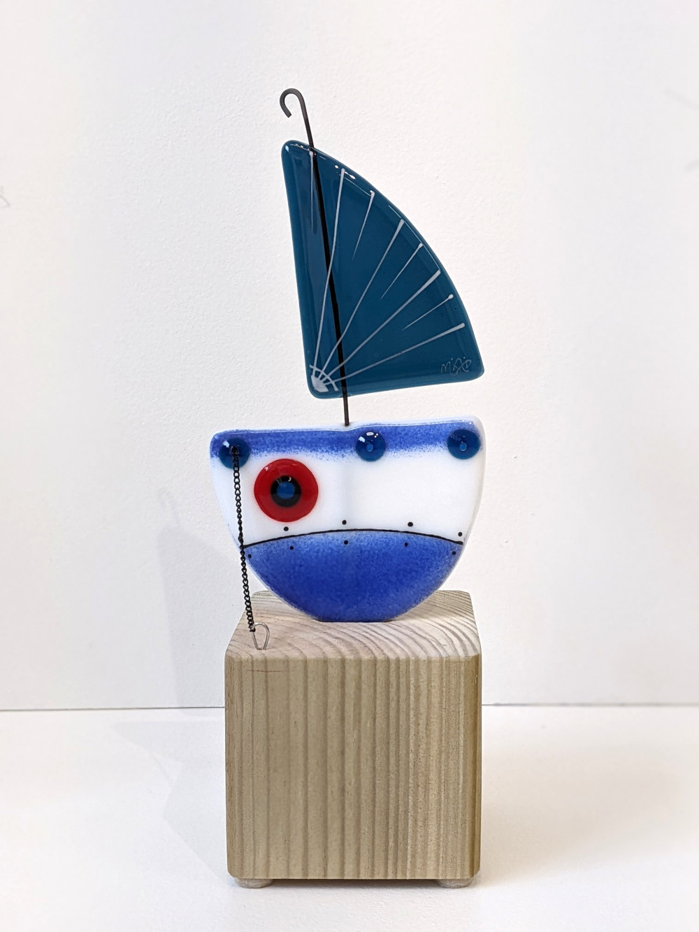 Boat on the Block Blue Sail Boats on the block handmade fused glass by Mother and Daughter glass. Blue boat with blue sail and red accents. The boat sits on a solid wooden plinth.