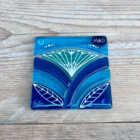Inspired by the iconic Lotus flower this handmade coaster is made using rich expressive blue and turquoise coloured glass and finished with delicate hand-painted details.