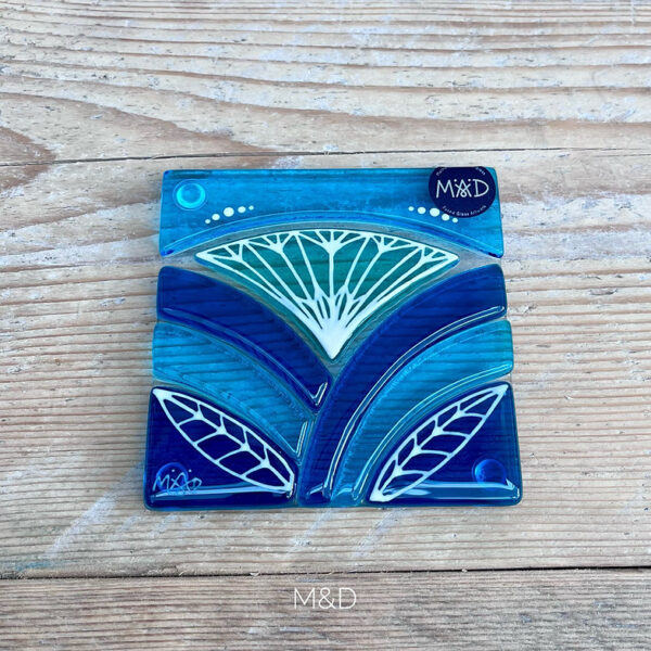 Inspired by the iconic Lotus flower this handmade coaster is made using rich expressive blue and turquoise coloured glass and finished with delicate hand-painted details.