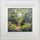 lake district art original oil painting by local artist Jeff Sudders. A woodland footpath with blossoming flowers blue skies peaking through the trees. Displayed in a white frame with wood grain.