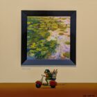 Whimsical painting of a frog riding a scooter with art supplies beneath a framed water lily painting, creating a playful gallery scene