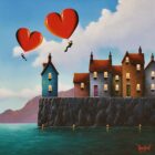 Colourful coastal village with heart-shaped hot air balloons.