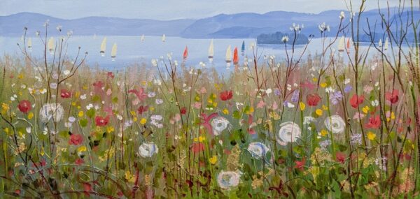 colourful wildflowers beside a tranquil lake with sailing boats and distant blue hills.