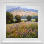 lake district art original oil painting by local artist Jeff Sudders featuring blossoming flowers in Borrans field over looking lake Windermere and fells. Displayed in a white frame.
