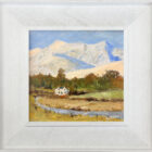 lake district art original oil painting by local artist Jeff Sudders featuring a cottage sitting before a snowy Blencathra and sunshine bouncing off the hills. Displayed in a white frame.