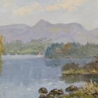 Autumn landscape with a calm lake, wooded shores, and distant mountains beneath a cloudy sky.