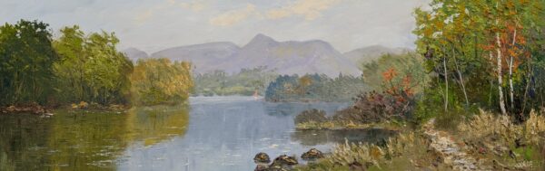 Autumn landscape with a calm lake, wooded shores, and distant mountains beneath a cloudy sky.