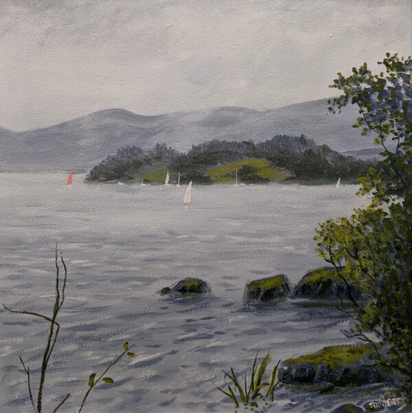 A misty lake with sailing boats, wooded islands, mountains and trees along the shore.