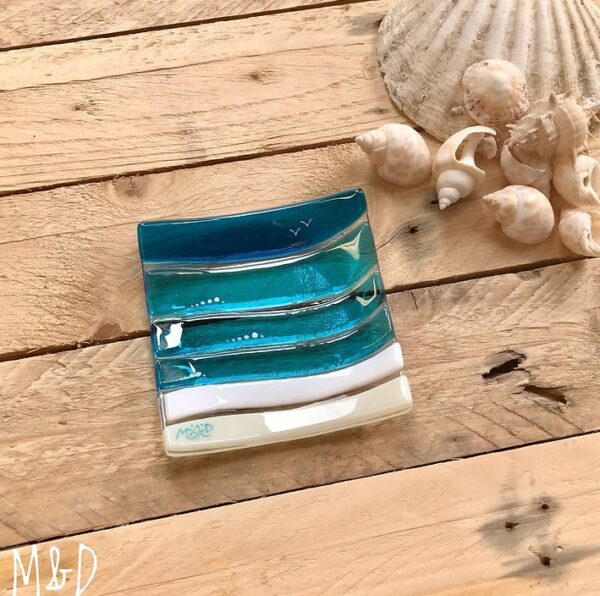 This beautiful trinket fused glass dish is made using colours of the sand and sea with additional hand-painted details made by Mother Daughter glass.