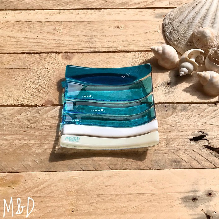 This beautiful trinket fused glass dish is made using colours of the sand and sea with additional hand-painted details made by Mother Daughter glass.