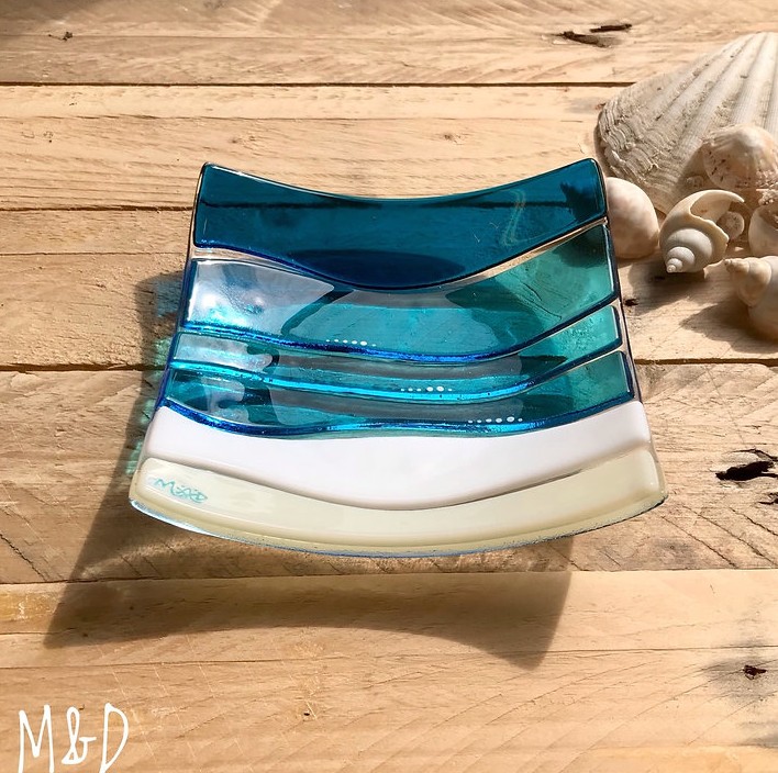 This beautiful trinket fused glass dish is made using colours of the sand and sea with additional hand-painted details made by Mother and Daughter glass.