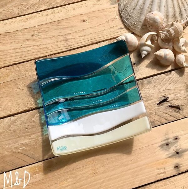 This beautiful trinket fused glass dish is made using colours of the sand and sea with additional hand-painted details made by Mother and Daughter glass.