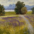 Landscape painting of a field with purple flowers, winding path, trees, lake and distant blue mountains.